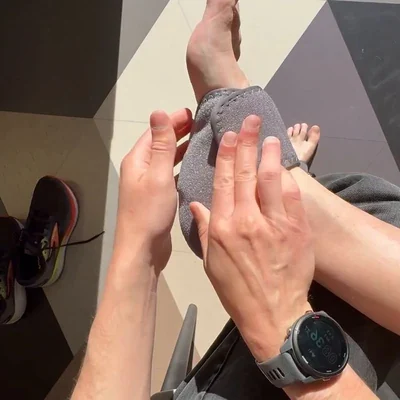 A palm smoothing the Stepeva wrap already fastened over the top of a foot, toes visible and a watch on the wrist